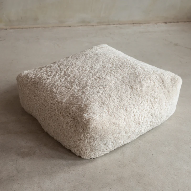 Coussin de sol peau de mouton bouclée blanc cassé