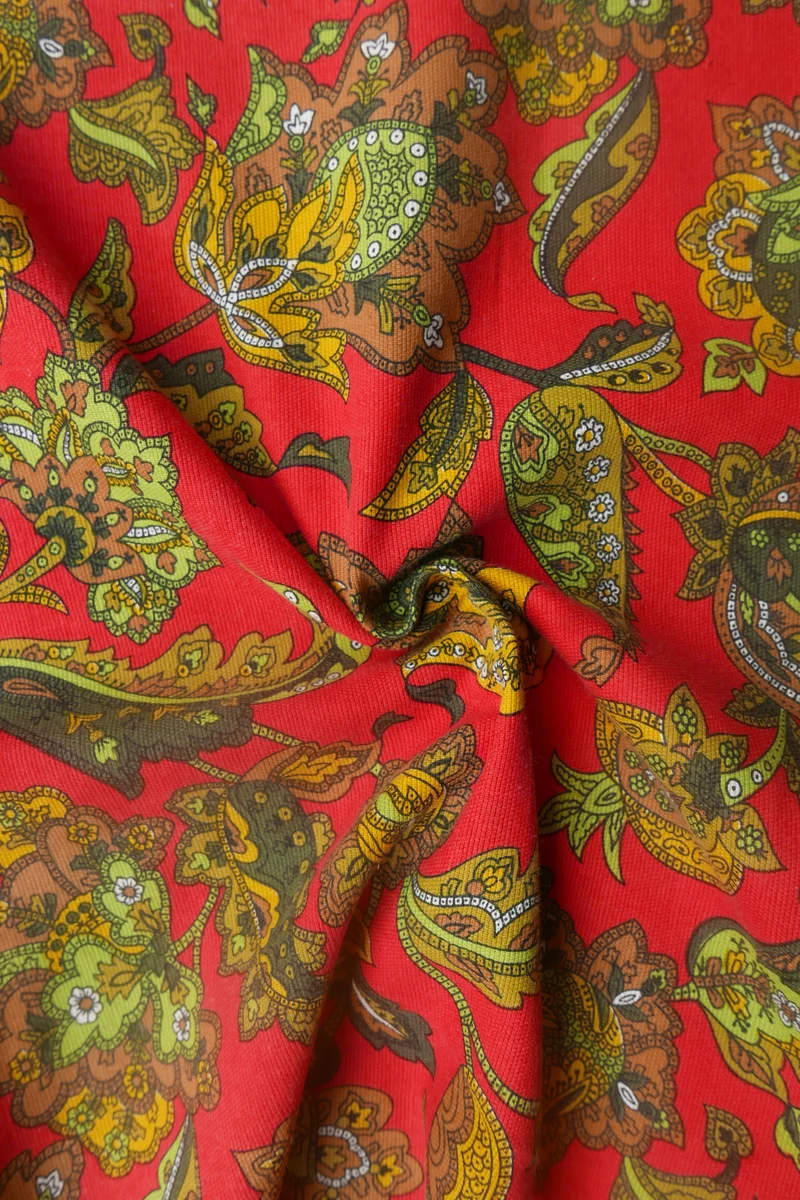 Tissu - Polyester - Fond rouge avec des arabesques aux teintes vertes - Imprimé en Angleterre - 131 cm * 217 cm